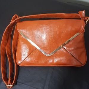 Tangerine Crossbody Purse w/ golden metal trim.